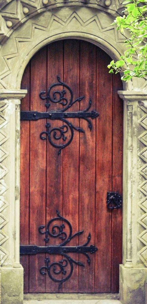 a wooden door with iron hinge work, in an arched doorway. Not a dungeon but the door to a church on the Clandeboye Estate in Northern Ireland.